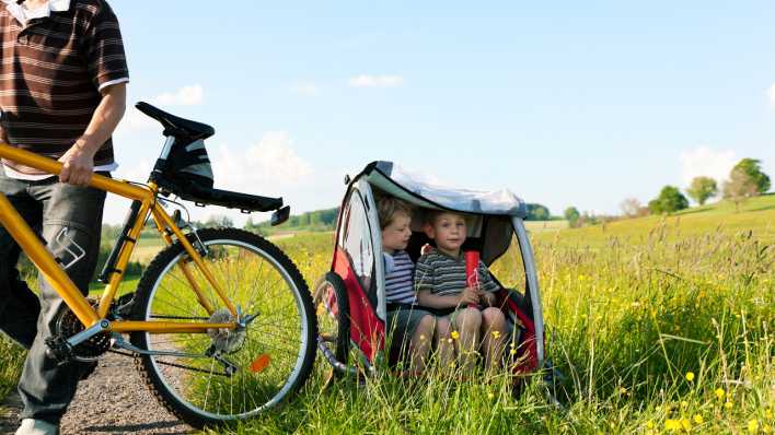 Kinder sitzen im Fahrradanhänger, Foto: Colourbox