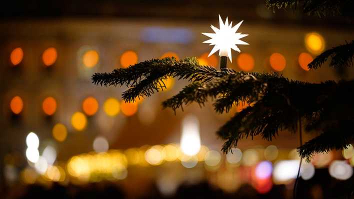 Weihnachtsstern an einem Tannenzweig. Bild: IMAGO/Thomas Bartilla